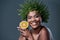 Achieve envy-worthy skin with a envy-worthy beauty regime. a beautiful woman holding an orange and wearing a leaf wreath