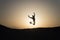 Achieve main goal. Silhouette man motion jump in front of sunset sky background. Future success depends on your efforts