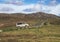 Achill, IRELAND - OCTOBER 10, 2022: A VW camper T5 parking in front of a mountain face in the Irish coast. Green meadows and trees