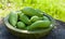 Achocha, Cyclanthera pedata healthy vegetables in wooden bowl on wooden log. Green nature background.