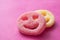 acidulous candies in shaped smiley on pink background