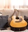 Acoustic guitar and cellphone on a sofa. White overexposed background. Grain