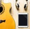 Acoustic Guitar with headphone and tablet for music