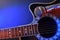 Acoustic guitar and microphone isolated with red and blue lights