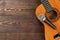 Acoustic guitar with microphone on wooden background.