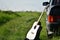 Acoustic guitar next to a black car in nature