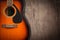 Acoustic guitar resting against a blank grunge background with c.