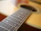 Acoustic wood guitar close up on wooden background with fretboard, strings, and tuners for music blogs, musician social media.