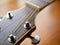 Acoustic wood guitar close up on wooden background with fretboard, strings, and tuners for music blogs, website banners.