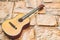 Acoustic yellow brown guitar on orange brick cobblestone surface