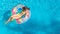 Acrive girl in swimming pool aerial top view from above, kid swims on inflatable ring donut , child has fun in blue water