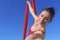 Acrobat athletic, close up portrait of an aerial gymnast with red fabrics outdoors on sky background. flexible woman in red suit