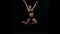 Acrobat girl jumps bending the knees. Slow motion. Black background