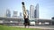 Acrobat keep balance on one hand with blurred Dubai cityscape. Concept of modern and healthy lifestyle.