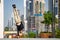 Acrobat keep balance one the hands with blurred Dubai cityscape. Concept of modern, business and unlimited possibility