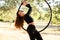 Acrobat making a pose on aerial hoop or circle among olive trees in summer