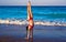 Acrobatic gymnastics bikini girl in a beach