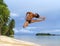 Acrobatic jump on tropical beach