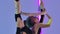 Acrobatic performance of a young circus performer on air silk. A girl in a black leotard whirls in the air against a