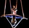 Acrobats perform a trick on slings suspended i