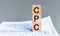 Acronym CPC - Cost per Click. Wooden small cubes with letters isolated on black background with copy space available