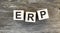 Acronym ERP- Enterprise resource planning. Wooden small cubes with letters isolated on black background with