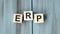 Acronym ERP- Enterprise resource planning. Wooden small cubes with letters isolated on black background with copy