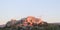 The Acropolis in Athens Greece at sunset with the pink light reflecting off it and pink clouds in the sky - people are watching th