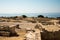 Acropolis ruins and a giant stone vase with Akrotiri bay in background, Cyprus