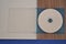 Acrylic cd and dvd case, white, blue and wood background, top view,