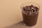 Acrylic cup with brigadeiro and chocolate sprinkles on brown background
