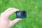 Action camera in hand close-up. Lens and small display with resolution, battery and memory card information