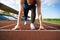 Action packed image of a female athlete leaving the starting blocks for a sprint run on a track