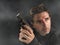 Action portrait of serious and attractive hitman or special agent man holding gun pointing the handgun at cinematic edgy