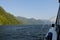 Action shot from the point of view of a person viewing from inside a boat, as it moves across the ocean with beautiful islands