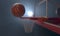 An action shot of a regular basketball teetering on the rim of a red basketball