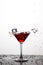 Action Splash Photography. Red Wine Glass With Splashes Against White