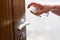 Actions to prevent the spread of COVID-19 coronavirus, door handle disinfection. Closeup of the hand wipes the door handle with a