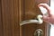 Actions to prevent the spread of COVID-19 coronavirus, door handle disinfection. Closeup of the hand wipes the door handle with a