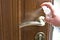 Actions to prevent the spread of COVID-19 coronavirus, door handle disinfection. Closeup of the hand wipes the door handle with a