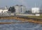 Activated sludge tank with aerated wastewater and anaerobic digesters in the background