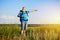 Active aged man with rucksack pointing at something in the field