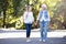 Active aging woman walking with mature daughter outdoors