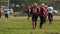 Active American football players changing field sides during game, amateur match