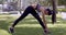 Active Asian woman diligently stretching in park