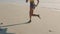 Active athlete legs keeping fit, running on the beach front of ocean or sandy seaside. Female jogger doing morning
