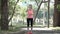 Active athletic young woman runner jogging in park. Fit female sport fitness training. Drinking water
