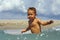 Active baby playing with sea water on beach