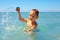 Active baby playing water game in the sea