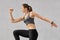 Active bodybuilder girl being photographed in motion, has dark pony tail, does stretching exercises dressed in casual clothes, pos